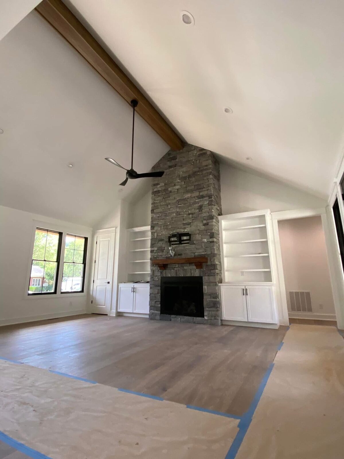 Great room with stone fireplace and exposed beams