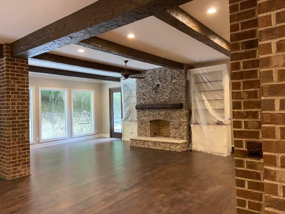 Living room with exposed beams and brick accent wall