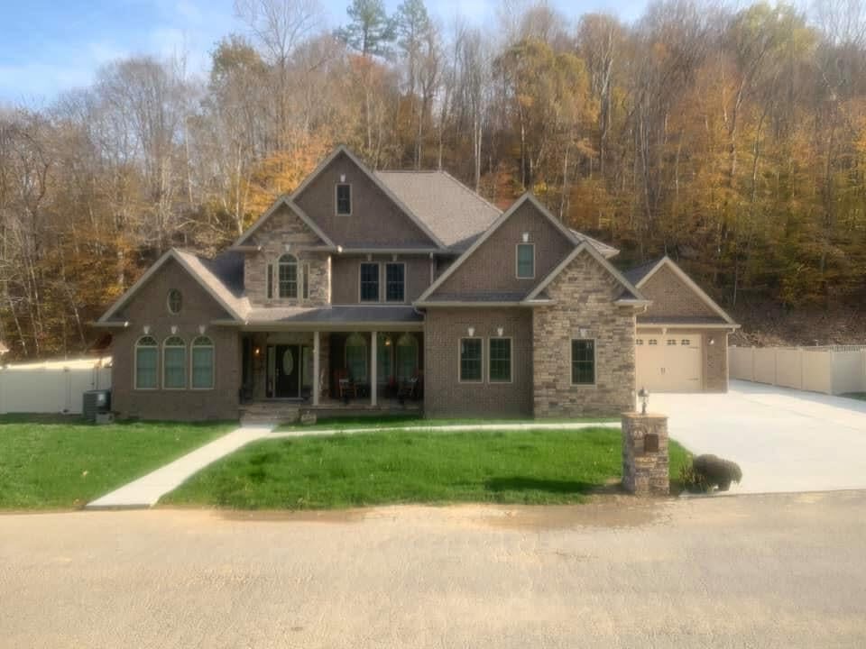 Brick and stone custom home with landscaped lawn