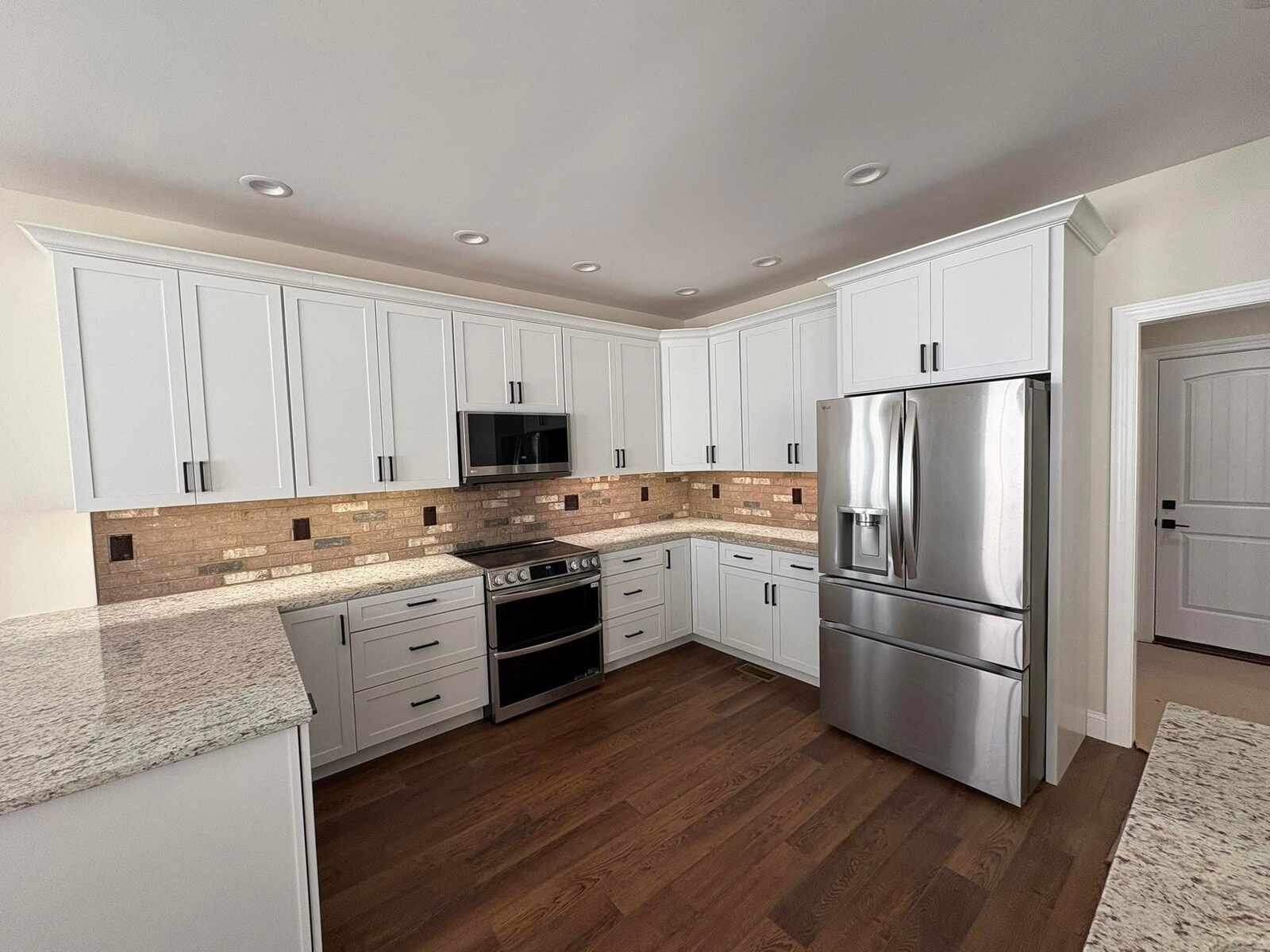 Custom kitchen with white cabinetry and stainless appliances
