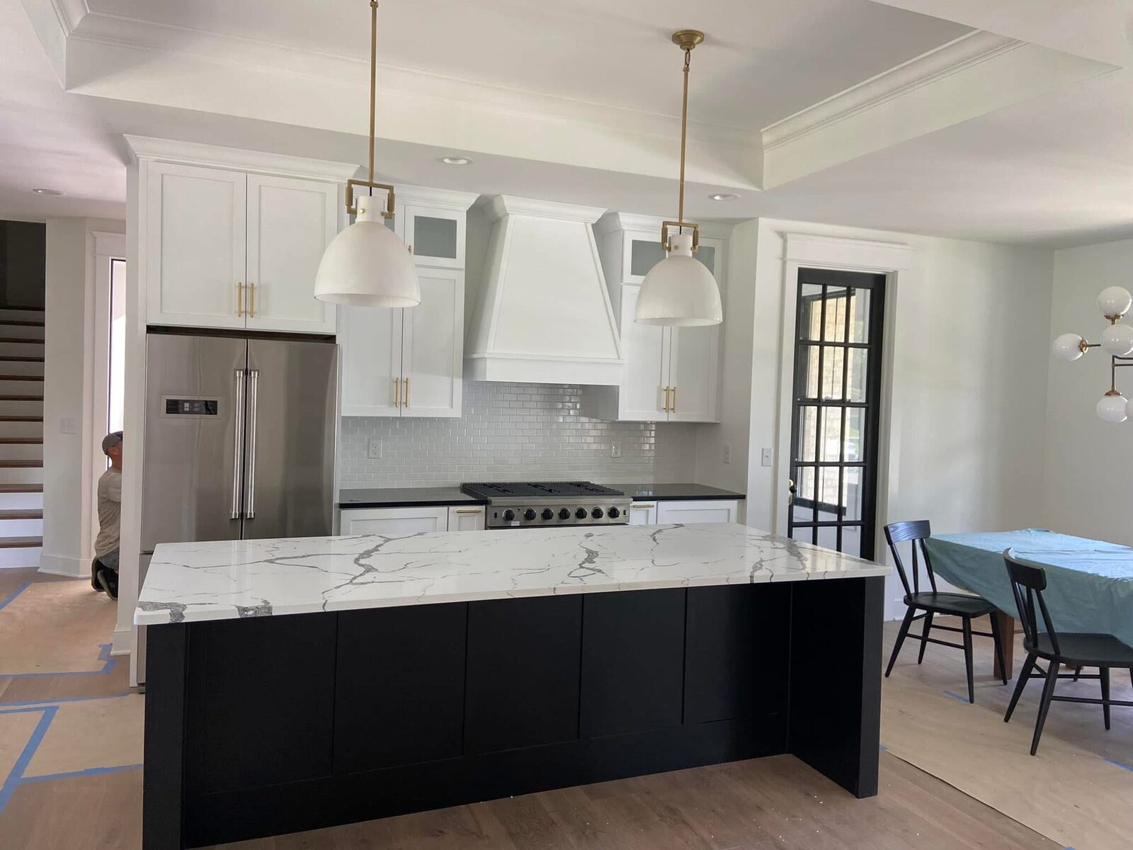 Modern kitchen with dark island and custom hood